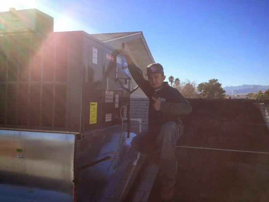 HVAC technician performing Heat Pump Repair on a rooftop unit in Temescal Valley